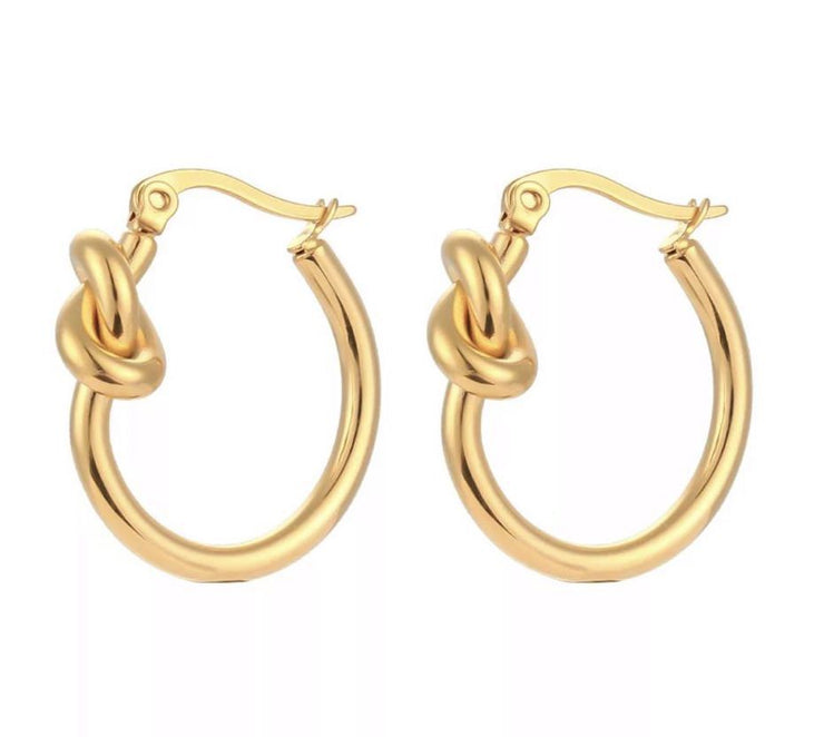 Gold love knot earrings in the form of a hoop.