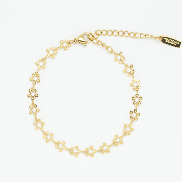 Flat lay of a gold plated chain made of small dainty gold flowers connected to make one bracelet