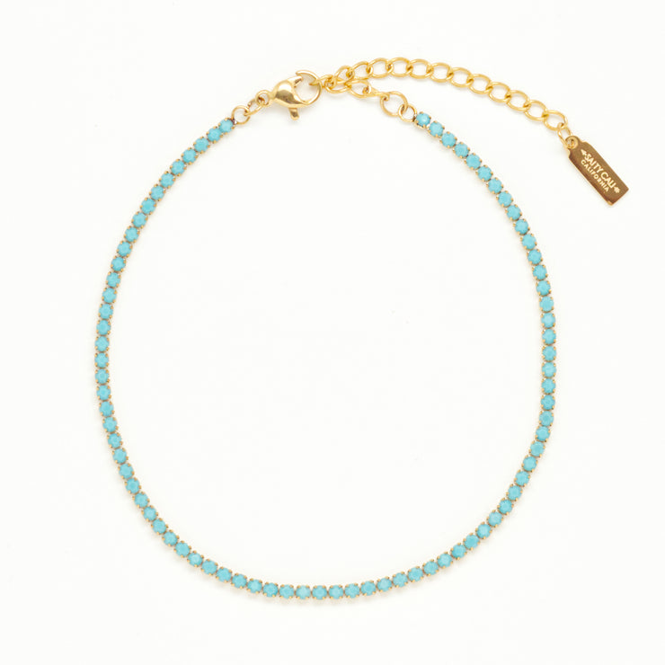 A blue tennis anklet with adjustable gold detail