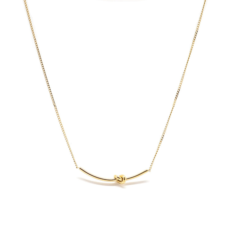 Gold love knot necklace on dainty gold chain.