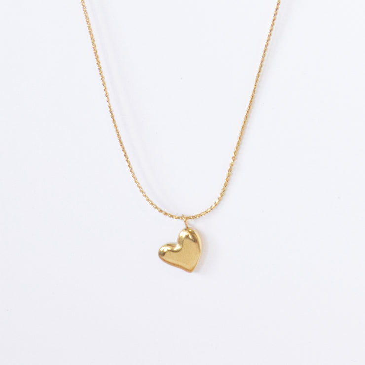 Dainty gold chain necklace with a small solid heart shaped gold pendant.