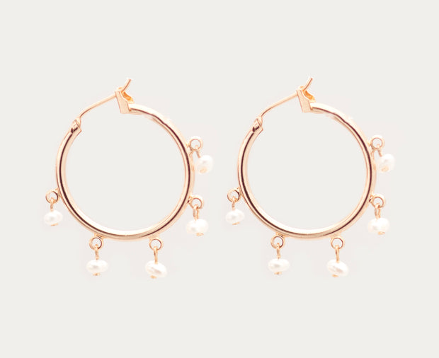 Small gold hoops accented with very small dangling white pearls.