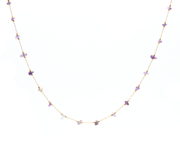 Gold chain necklace connected by small purple amethyst stones beaded together on an adjustable necklace.