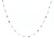 Gold chain necklace connected by small purple amethyst stones beaded together on an adjustable necklace.